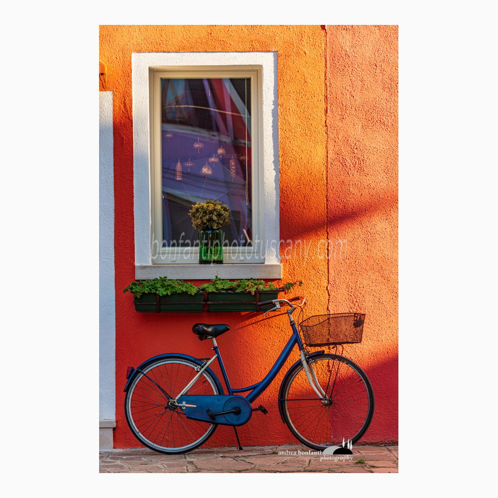 finestra e bici su fondo arancio in luce radente.jpg
